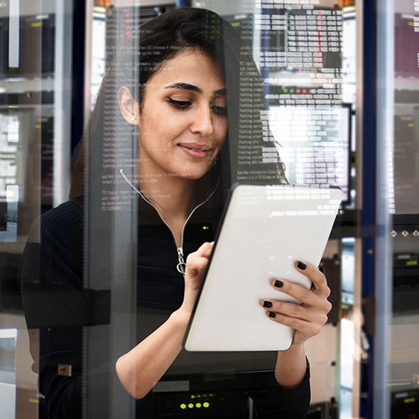 Woman standing in a server room working on cloud migration via full-stack observability from AWS Partner AppDynamics